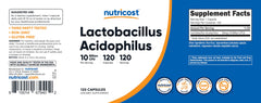 Nutricost botella junto a ingredientes naturales simbólicos
