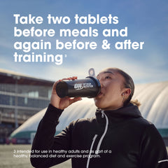 Optimum Nutrition cápsula junto a moneda para comparar tamaño