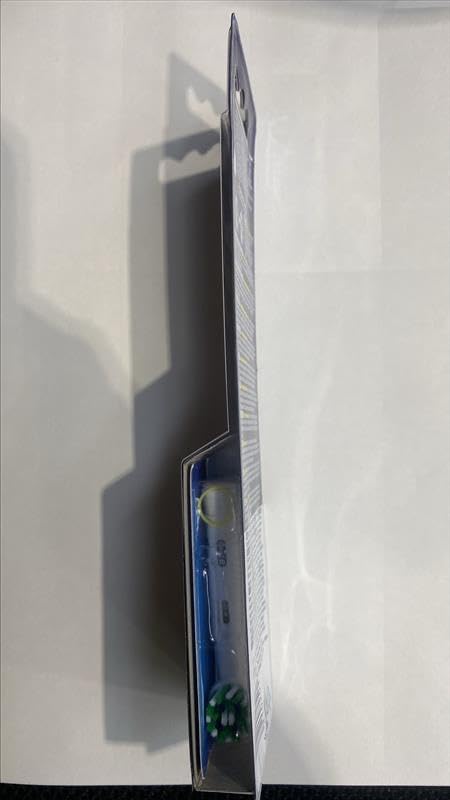 Comparación de tamaño Oral-B CrossAction junto a una moneda para visualizar escala y facilidad de uso