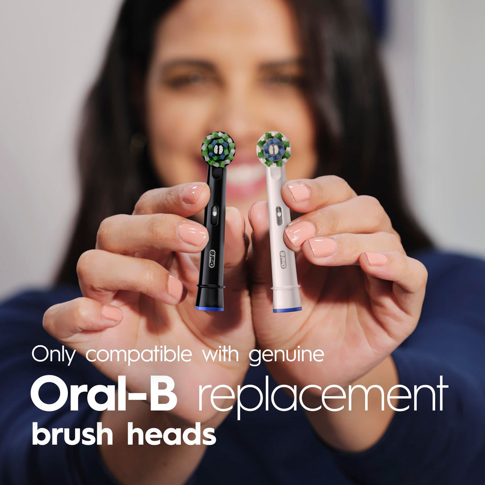 Oral-B Pro 100 junto a un vaso para comparar tamaño y ergonomía