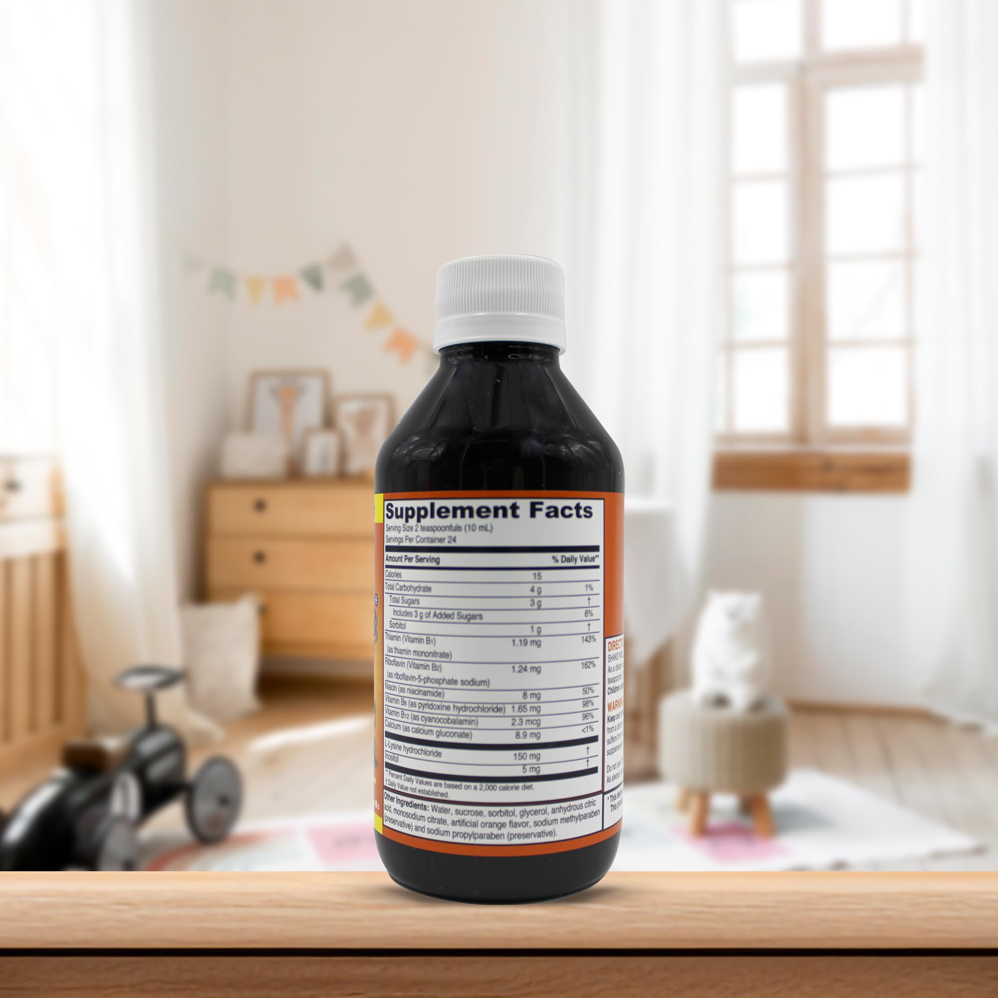 PHARMADEL GirafKids frasco junto a mano adulta para referencia de tamaño