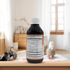 PHARMADEL GirafKids frasco junto a mano adulta para referencia de tamaño