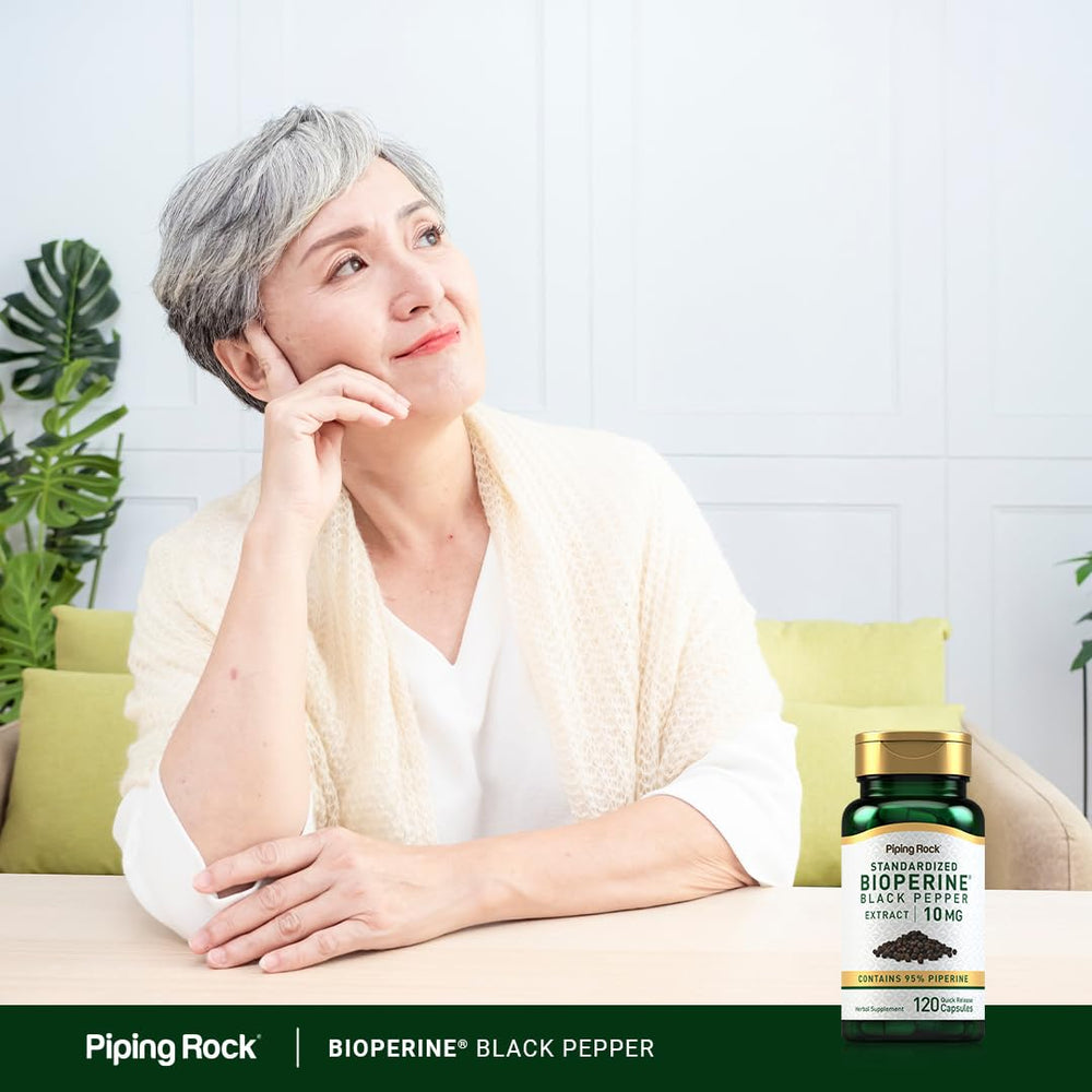 Piping Rock cápsulas junto a granos de pimienta negra ilustrando origen