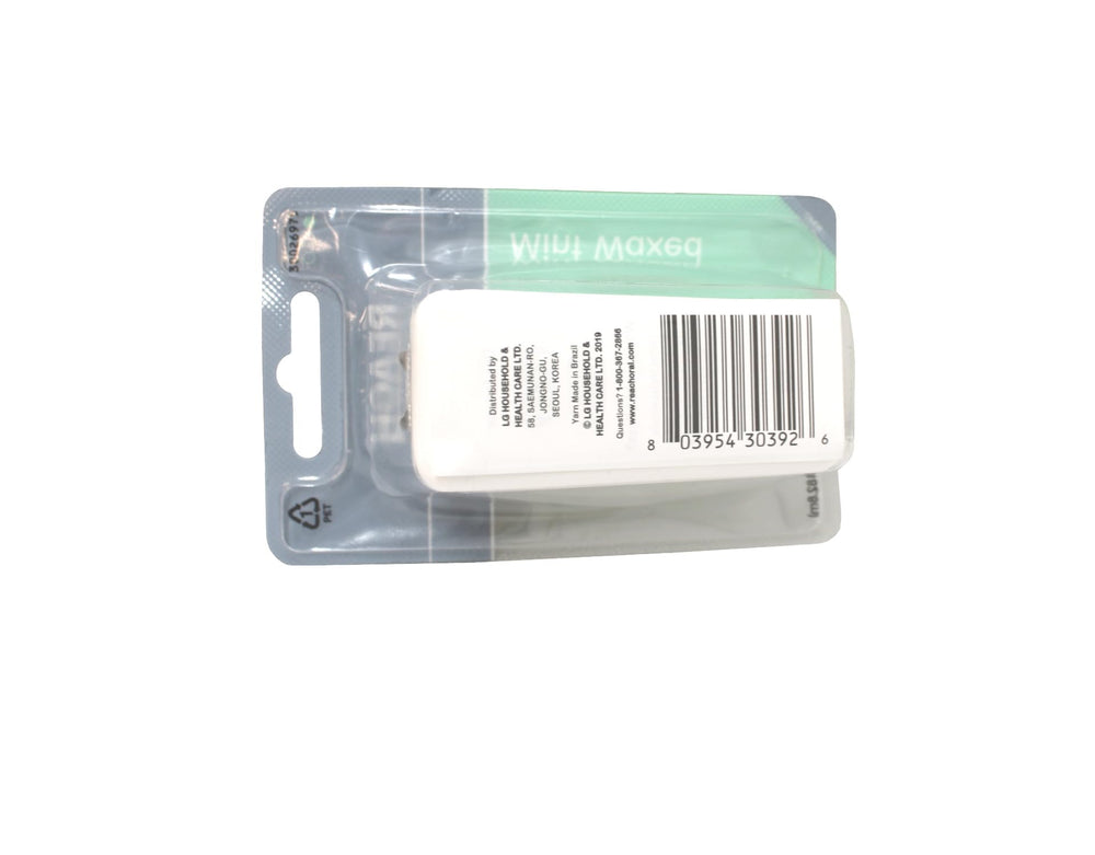 Persona usando Reach hilo dental encerado en baño, beneficiando la limpieza interdental