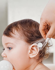 Slizy parche aplicado en oreja de bebé durante baño para protección acuática segura
