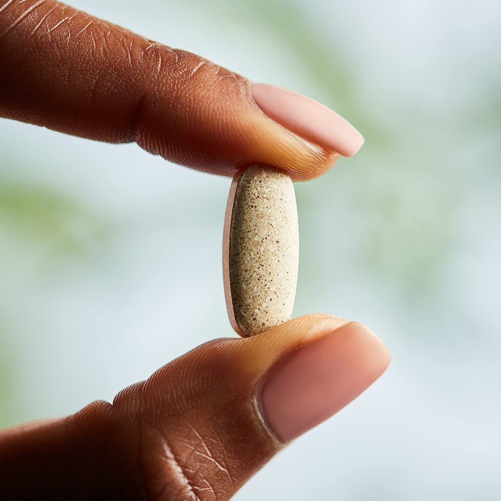 Solgar Nutrientes Prenatales, mano sosteniendo tabletas, opción práctica para tomar.