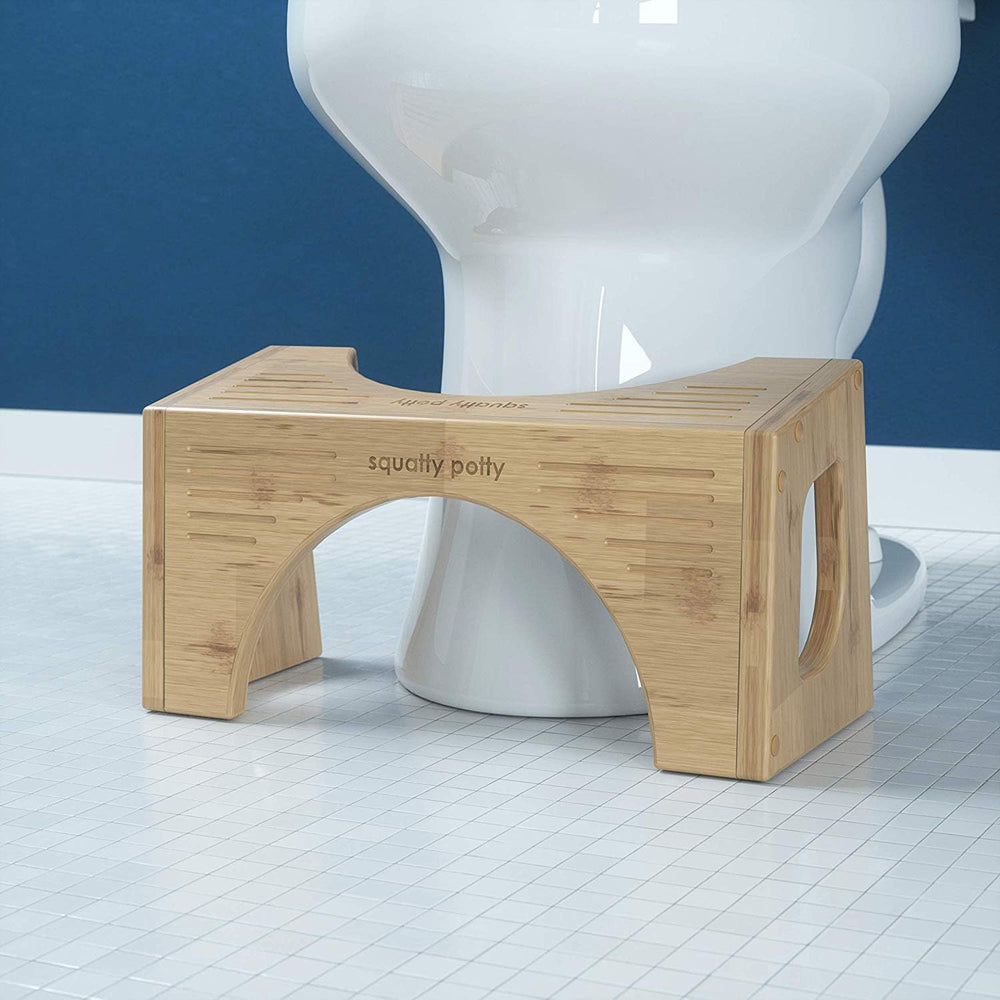 Persona usando Squatty Potty Bamboo Flip para apoyar los pies y mejorar postura