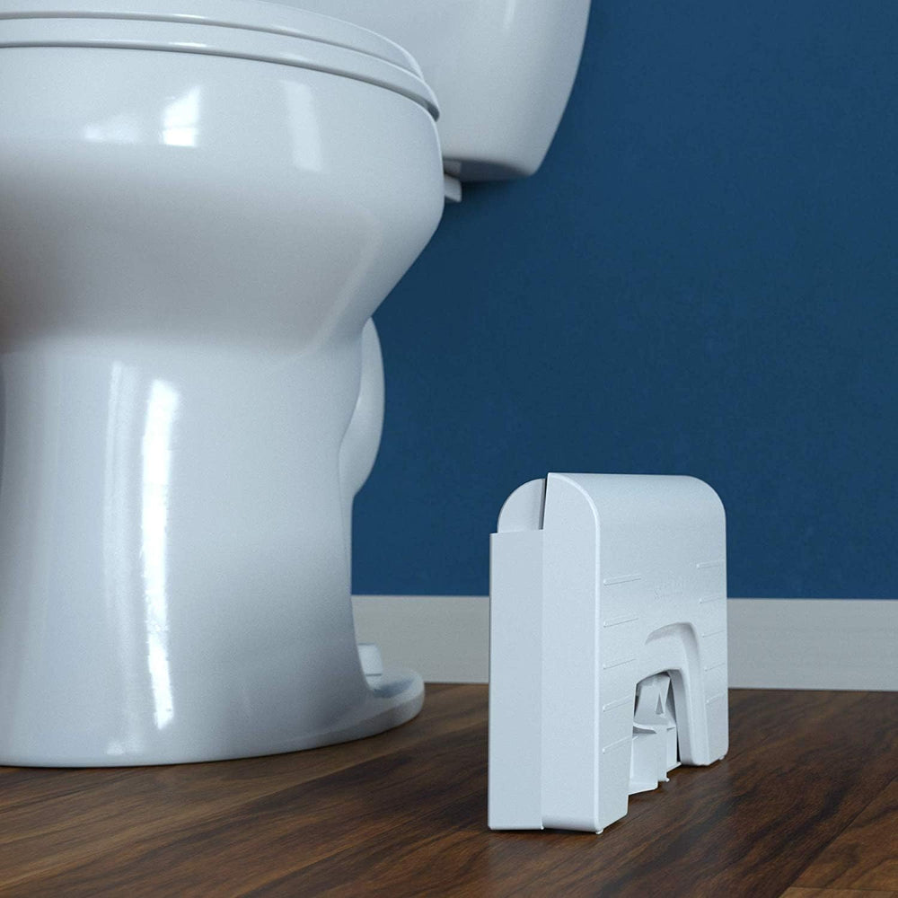 Squatty Potty plegado al lado del inodoro mostrando ahorro de espacio y fácil almacenamiento