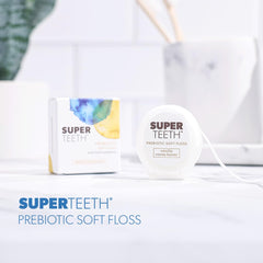 SUPER TEETH hilo dental en uso entre dientes limpiando suavemente encías