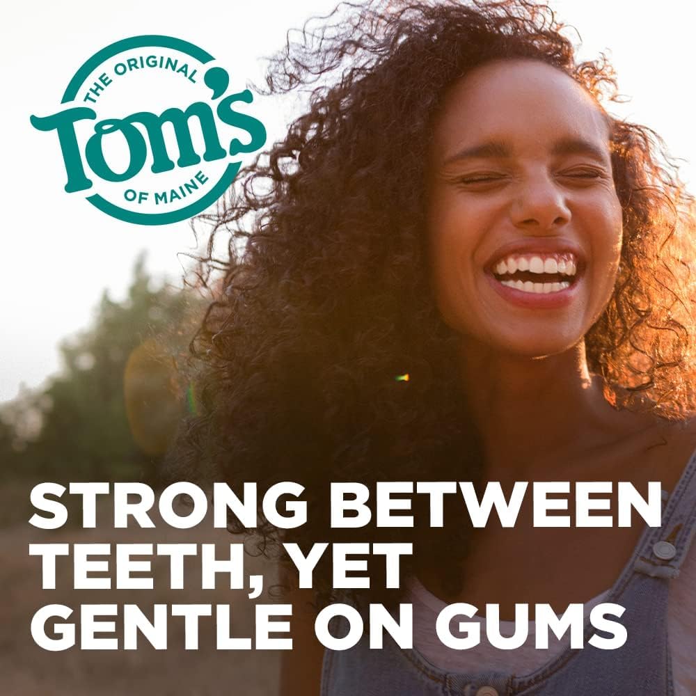 Tom's of Maine hilo en uso entre dientes demostrando limpieza efectiva