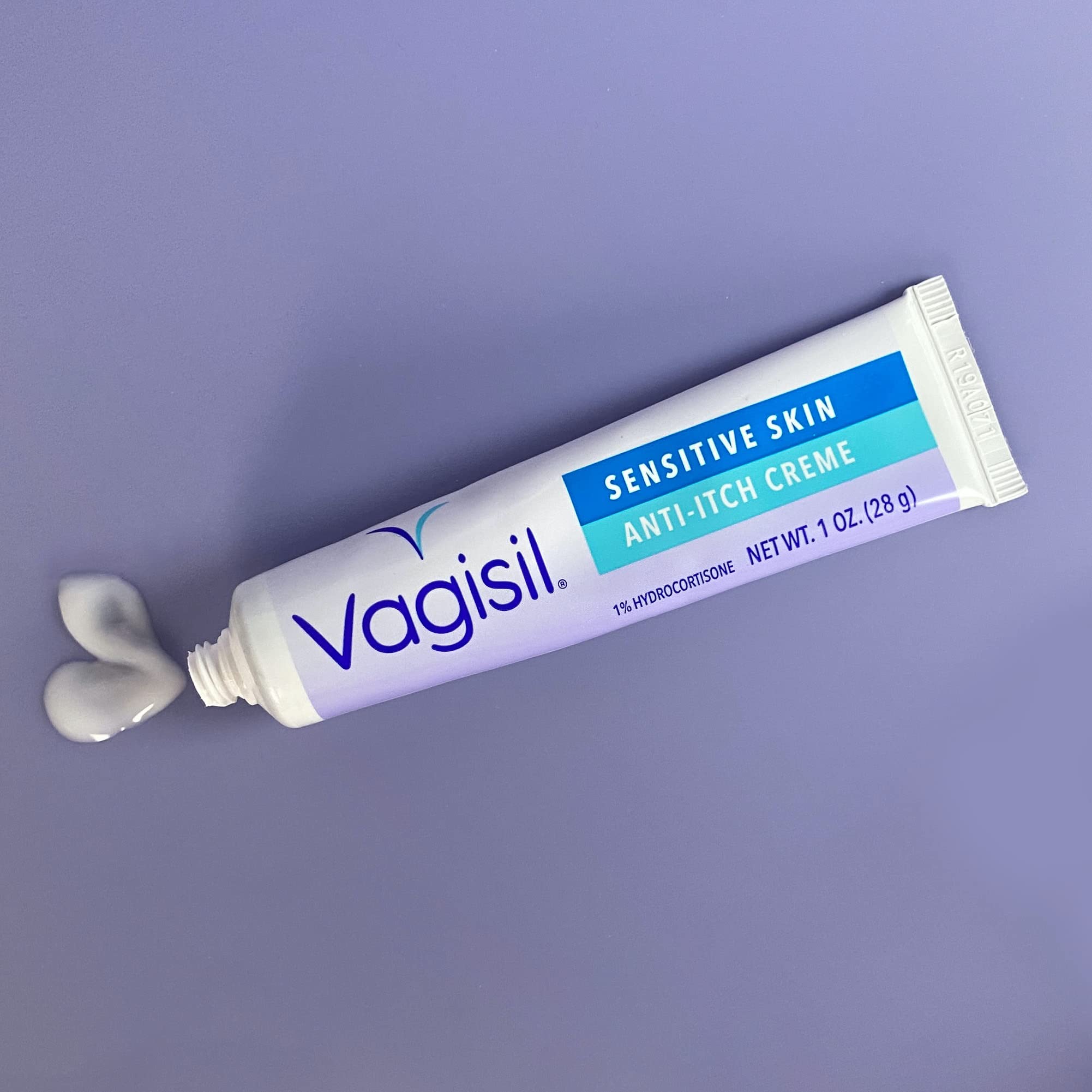 Vagisil tubo de 1 oz junto a moneda para comparar tamaño, práctico para llevar