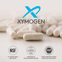 XYMOGEN cápsulas junto a una moneda para apreciar tamaño real