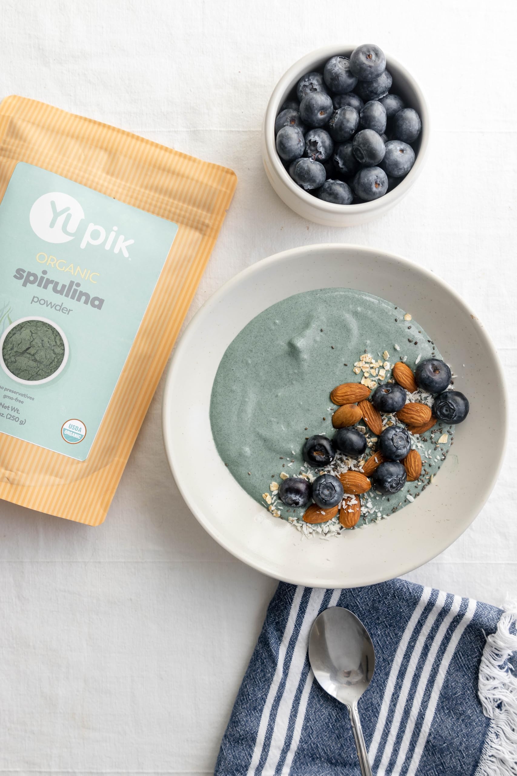 Yupik spirulina porción comparativa con cucharita para control de dosis